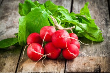 Parlak taze organik turp dilimleri ve kesme tahtası üzerinde yeşil soğan ile