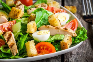 Sezar salatası kruton, bıldırcın yumurtası, kiraz domates ve ızgara tavuk yakın çekim