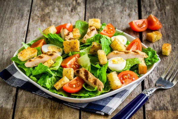 Salade César au poulet grillé, croûtons, œufs de caille et tomates cerises — Photo