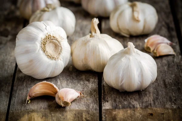 Organické garlics s hřebíčkem na dřevěné pozadí — Stock fotografie