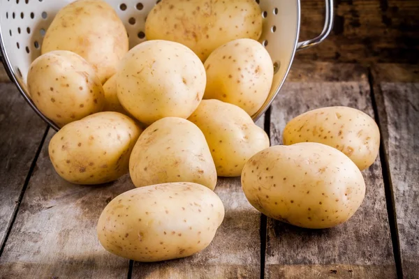 Fresh organic raw potatoes  in a colander — Stock Photo, Image