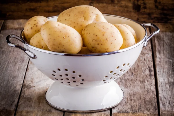 Patatas crudas orgánicas frescas en un colador — Foto de Stock