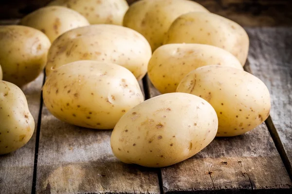 Patate fresche biologiche crude sul vecchio tavolo — Foto Stock