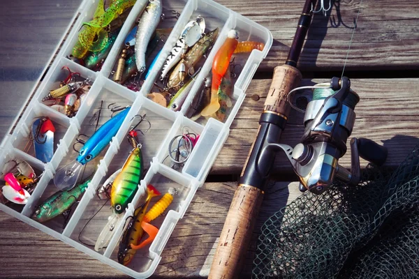 Fishing Lures in tackle boxes with spinning rod and net — Stock Photo, Image