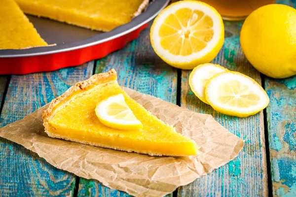 Piece of lemon tart on baking paper — Stock Photo, Image