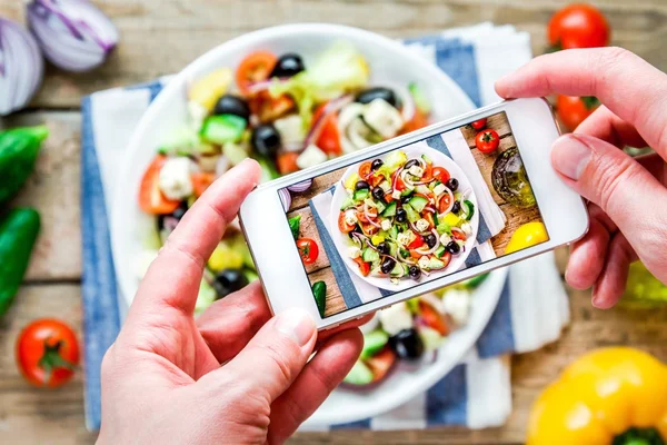 Smartphone taking picture from greek salad