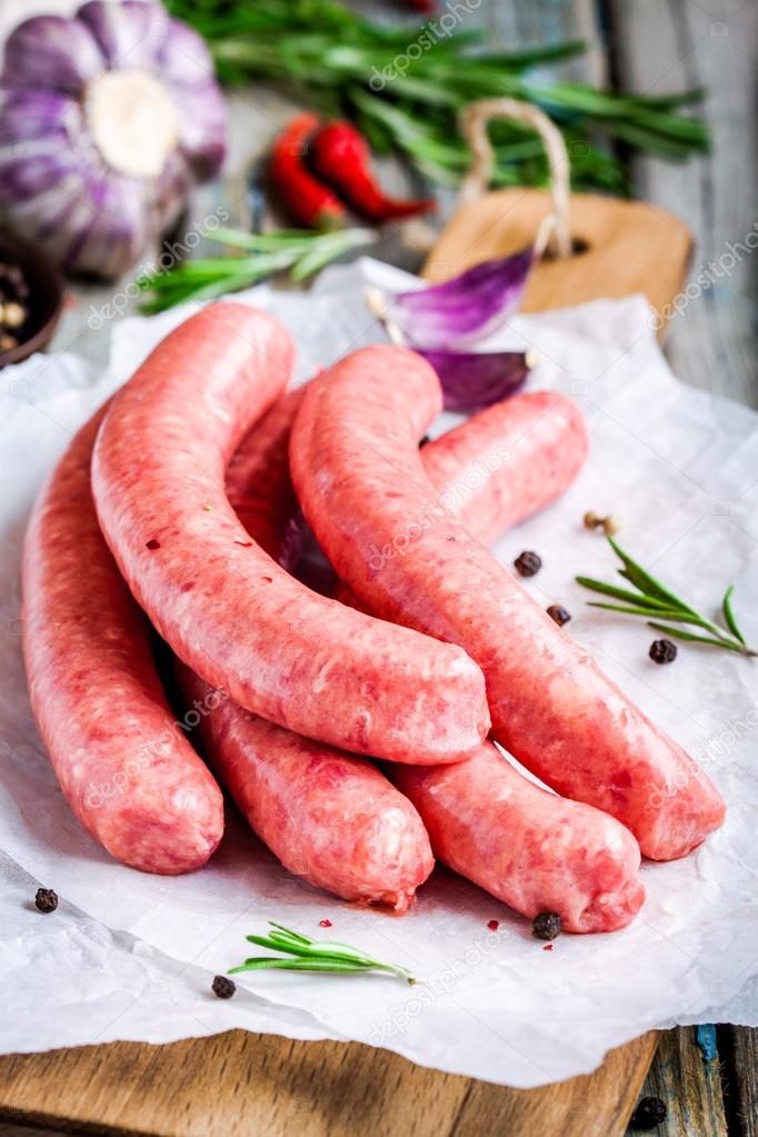 raw homemade sausages on cutting board