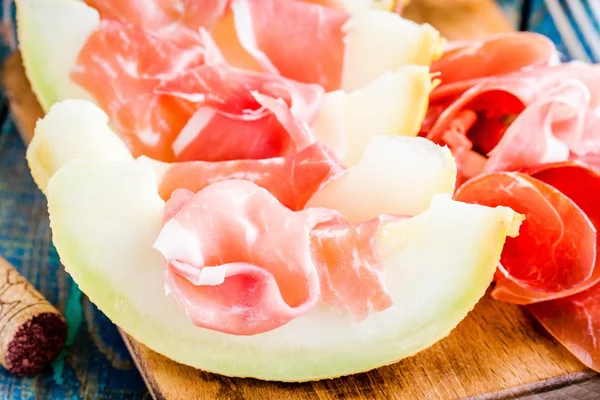 Melon with thin slices of prosciutto — Stock Photo, Image