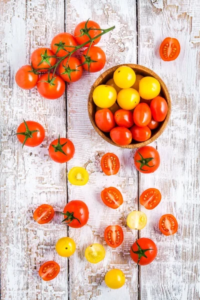 Tomates cereja amarelos e vermelhos na mesa de madeira branca velha — Fotografia de Stock