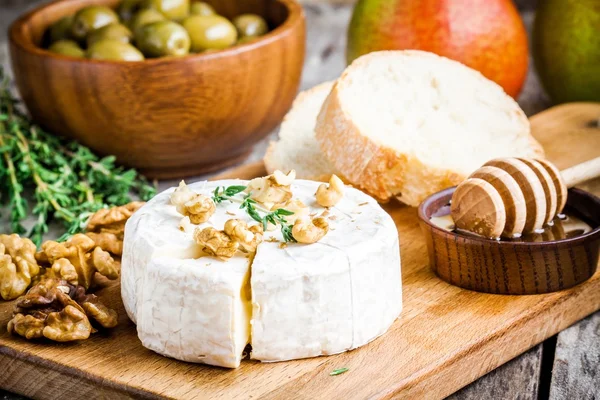 Сир камамбер з волоськими горіхами, медом та багетом — стокове фото