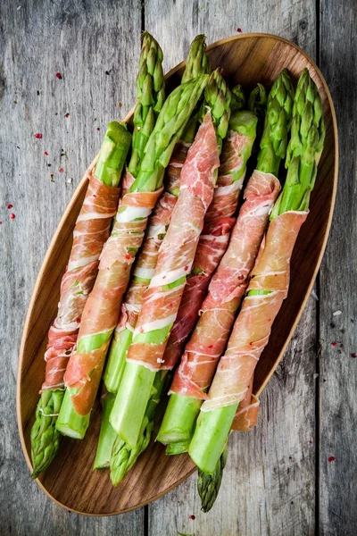 Świeże szparagi organicznych owiniętego szynką parmeńską w misce — Zdjęcie stockowe