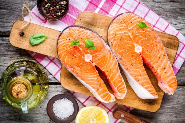 Dois bifes de salmão crus frescos com sal, pimentos e azeite — Fotografia de Stock