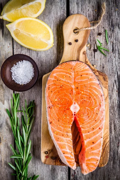 Filete fresco de salmón crudo con sal, limón y rasemary — Foto de Stock