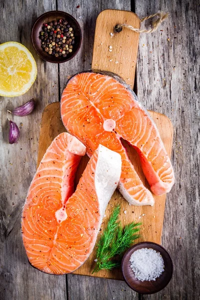 Två färska rå lax biffar med salt, paprika, citron, vitlök och dill — Stockfoto