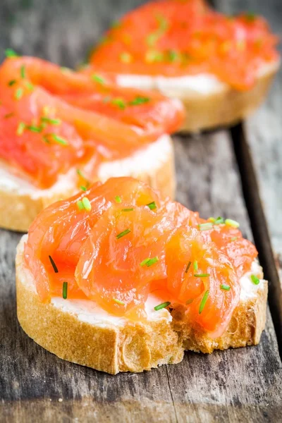 Appetizer canapes of baguette with smoked salmon — Stock Photo, Image