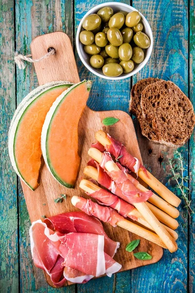 Semmelstangen mit Schinken, Melone, Oliven und Brot — Stockfoto