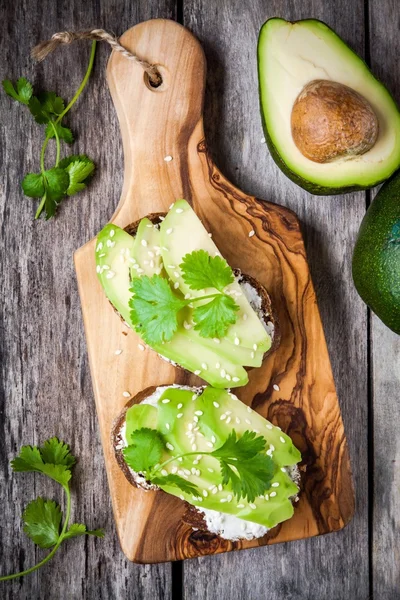 Panini con pane di segale, avocado affettato, semi di sesamo e prezzemolo — Foto Stock