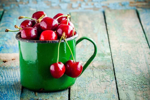 Reife saftige Kirschen im alten Becher — Stockfoto