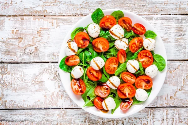 Salad of mozzarella, cherry tomatoes and spinach with balsamic sauce — Stock Photo, Image