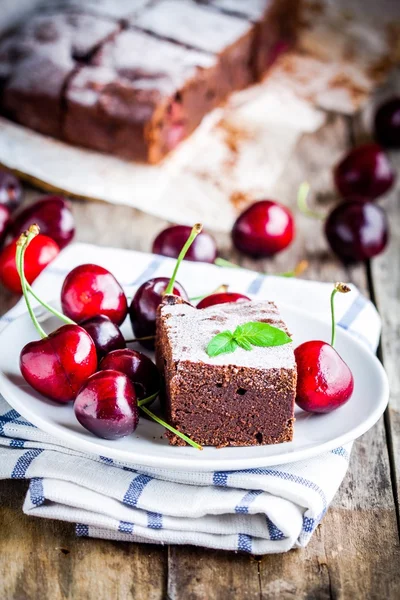 A piece of homemade chocolate brownie dessert with a cherry — ストック写真