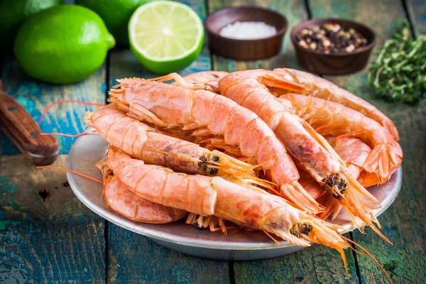 Fresh raw shrimps in a bowl with salt, pepper, lime — Stockfoto