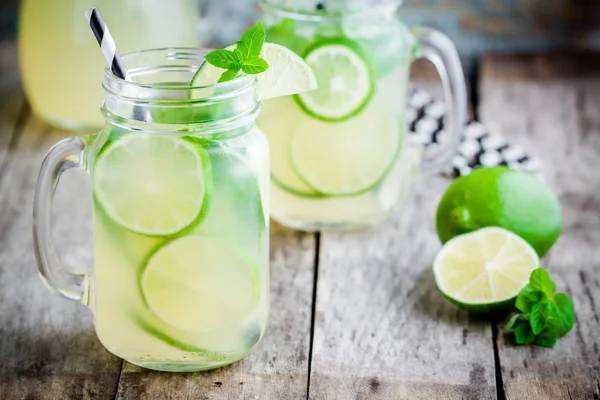 Hausgemachte Limonade mit Limette, Minze im Einmachglas auf einem Holztisch — Stockfoto