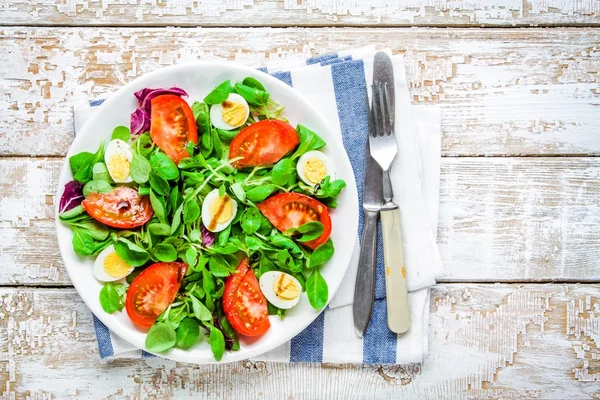 Fresh green salad with lamb's lettuce, tomatoes and quail eggs — Stock Photo, Image