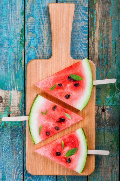 Scheiben frische, saftige Wassermelone auf einem Schneidebrett mit Minze — Stockfoto