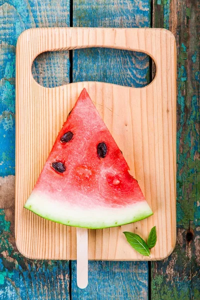 Scheibe frische, saftige Wassermelone auf einem Schneidebrett mit Minze — Stockfoto