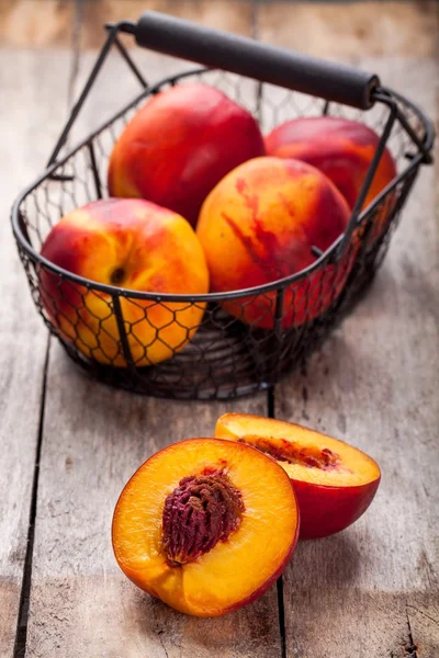 Fresh organic nectarines in a basket closeup — Stock Photo, Image