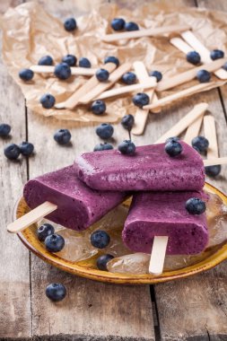 Yaban mersini ve ahşap kase yoğurt ile ev yapımı popsicles