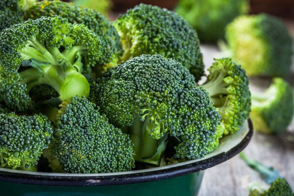 Fresh raw organic broccoli in bowl closeup