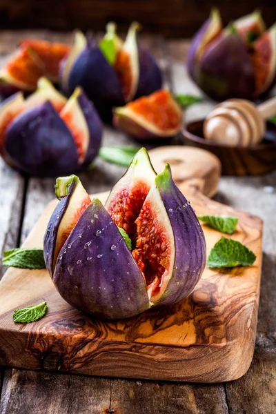 Fresh ripe figs with honey and mint leaves — Stock Photo, Image