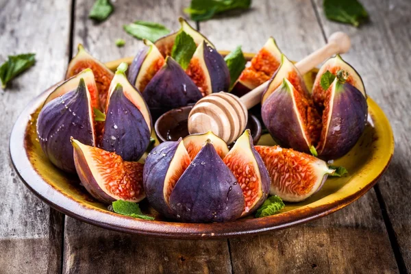 Fresh ripe figs with honey and mint leaves — Stock Photo, Image