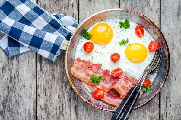 Завтрак с яичницей, беконом, помидорами и петрушкой — стоковое фото