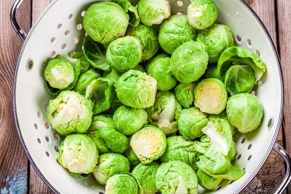 Fresh organic Brussels sprouts in a colander — Stock Photo, Image