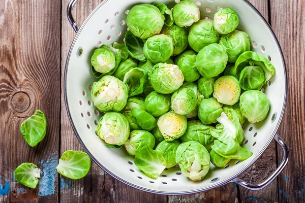 Fresh organic Brussels sprouts in a colander — Stock Photo, Image