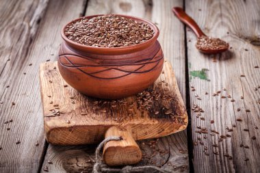 ahşap bir masa üzerinde bir kapta keten tohumu