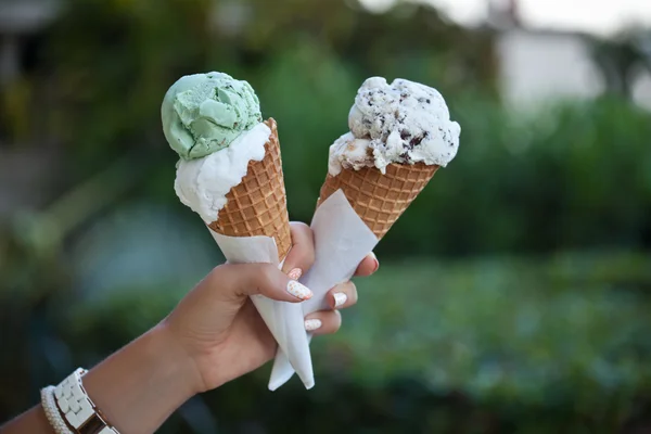 Mano che tiene un gelato coni — Foto Stock