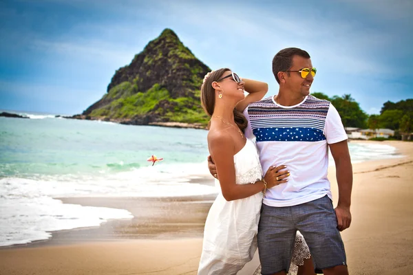 Couple on beach smiling holding around each other — Stock Photo, Image