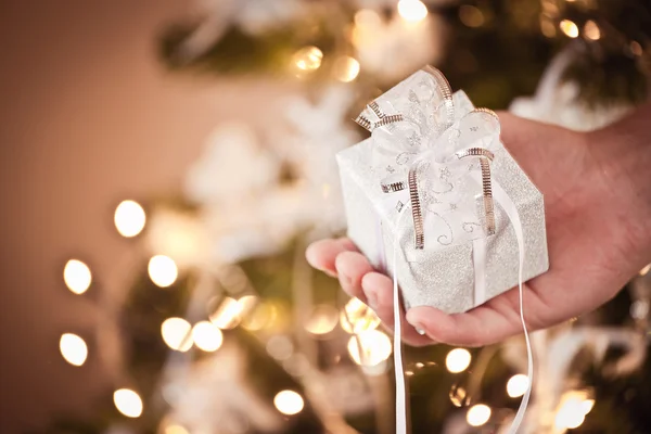 Mano con un piccolo regalo di Natale — Foto Stock