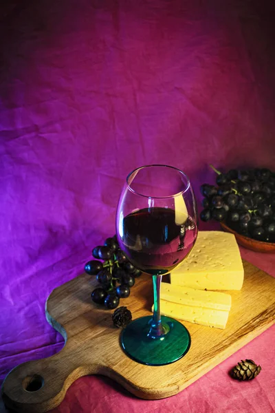 Ein Glas Rotwein Mit Käse Und Trauben Nahaufnahme Auf Violettem — Stockfoto