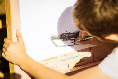 Küçük bir sanatçı. Bir çocuk sehpaya bir şeyler çizer..