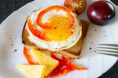 Lezzetli ve sağlıklı bir kahvaltı. Peynirli ve domatesli bir tost makinesinde çırpılmış yumurta..