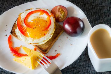 Lezzetli ve sağlıklı bir kahvaltı. Peynirli ve domatesli bir tost makinesinde çırpılmış yumurta..