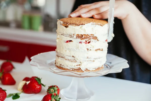 Mulher cuidadosamente gelando o bolo — Fotografia de Stock