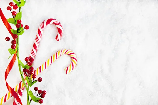 Dos bastones de caramelo con decoración de Navidad sobre fondo cubierto de nieve —  Fotos de Stock