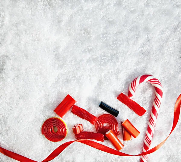 Snöiga bakgrund med färgglada karameller — Stockfoto