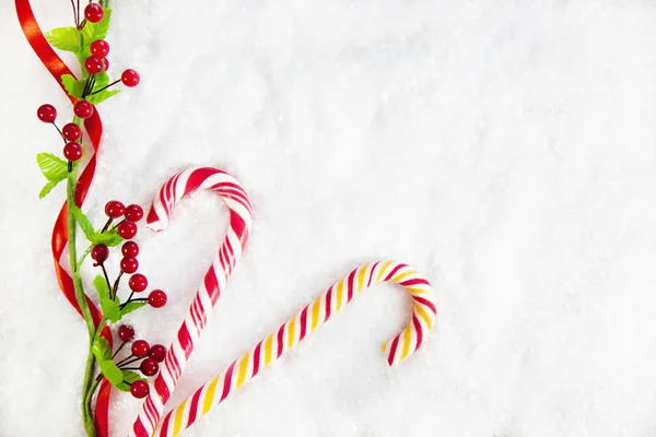 Dos bastones de caramelo con decoración de Navidad sobre fondo cubierto de nieve —  Fotos de Stock