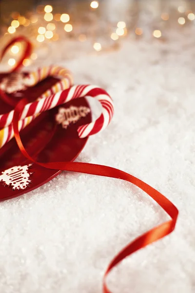 Bastones de caramelo en la placa roja con la decoración de Navidad alrededor —  Fotos de Stock